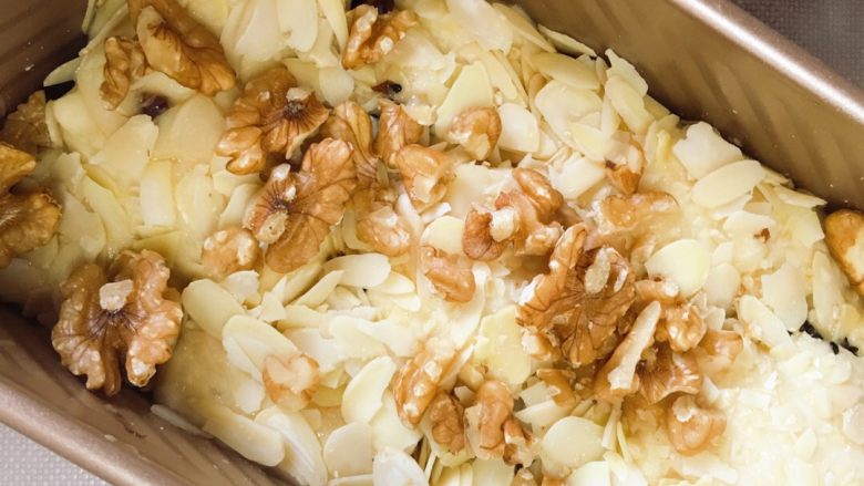 适合撕着吃的炼乳吐司,第二次发酵完成大概有七八分满,涂抹上剩余的炼乳汁,撒上杏仁片和核桃。烤箱190度预热,烤40分钟左右。我试过两次,30分钟左右上色不深,所以多烤了一会!