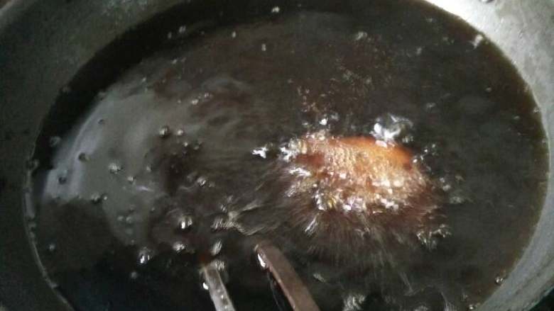 松阳特色小吃灯盏盘,油炸到四边微微发黄,在油锅里轻轻晃动勺子,灯盏盘可以自己脱模,漂浮在油上面。轻轻翻动,看到所有面糊都炸得金黄了,就可以出锅了。