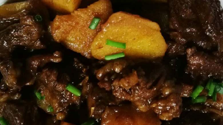 土豆烧牛腩,出锅装盘撒葱花。