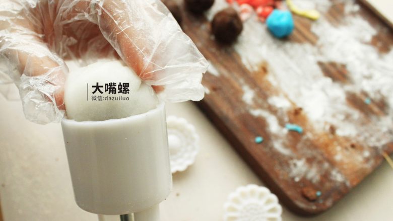 Q萌红糖冰皮月丨大嘴螺,包好后的冰皮红豆沙裹一层熟糕粉,放入模具中压紧实,顺着模具压就完成了