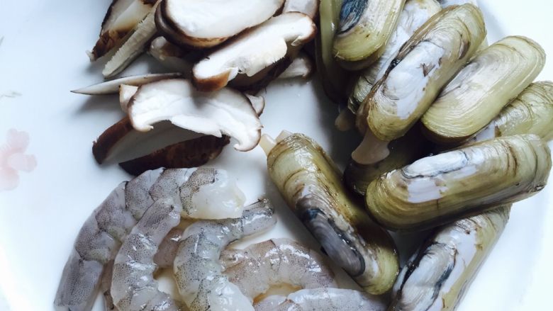 #年夜饭#海鲜炒粉干,把基围虾去壳挑线成虾仁,蛏子洗净用盐水浸泡片刻,使蛏子吐出泥沙,香菇切丝