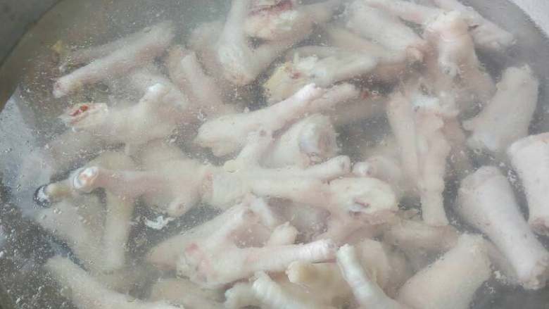 泡椒凤爪,水开了放一小汤匙白醋，把鸡爪放进去煮熟透，大概十分钟。