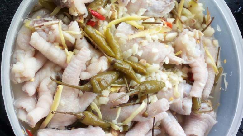 泡椒凤爪,把泡好冰水的鸡爪捞出和调制好的泡椒搅拌均匀。