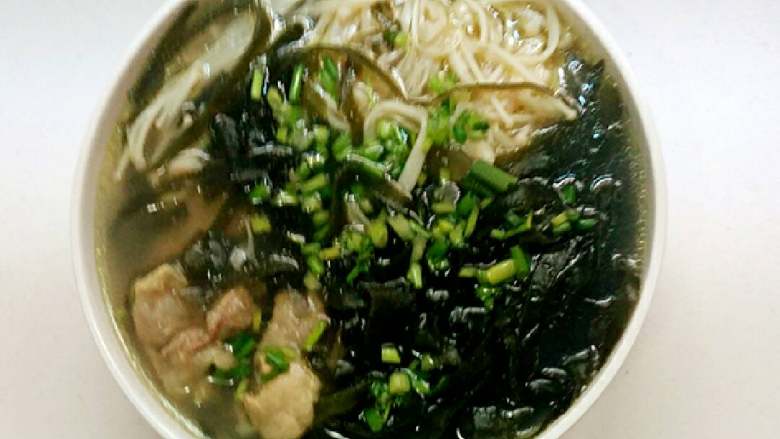 海带金针菇排骨汤,加入一点点鸡精拌匀即可关火,盛入汤碗中,撒上葱花。
