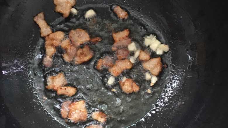 爆炒双色甘蓝,将三层肉放入锅内放少许的油煸香,放入蒜瓣炒香。