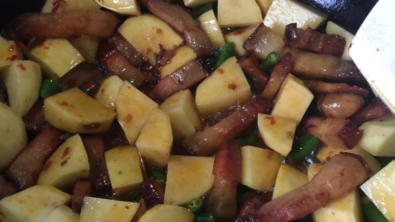 腊肉烧土豆,倒入青椒，土豆翻炒。