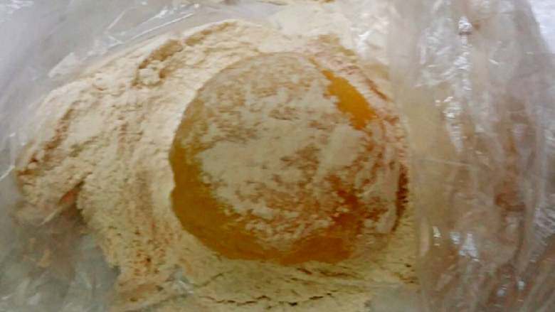 南瓜冰皮水果月饼+#中秋食饼记#,把做好的冰包放熟面粉中来回滚一下,