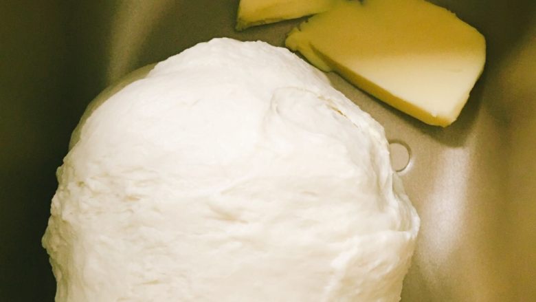 像棉花糖一样柔软的牛奶吐司,放入切成小块的黄油，我发现一个容易出手膜的技巧：先放入15g黄油，揉20分钟左右，然后1次1g黄油放入两三次揉匀之后，取出面团加入剩下的黄油手揉均匀即可。