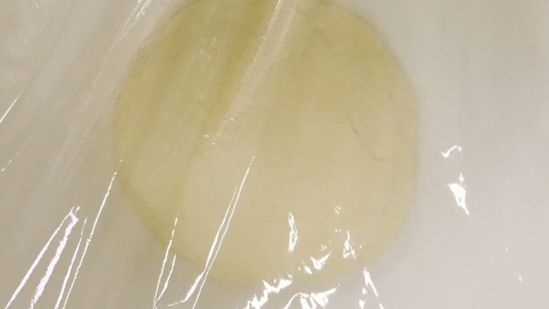 像棉花糖一样柔软的牛奶吐司,揉成团，盖上保鲜膜，室温发酵成2.5倍大小左右，大约需要一小时左右。发酵时间视自己情况而定，今天上海比较凉快，温度只有二十几度。发酵时间过长或者温度过高的话，成品的面包会有酒味哦！