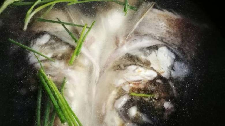 糟泥鱼头豆腐汤,煎好后加入葱段姜片和适量冷水盖过鱼头,开大火烧开,此间可以不加锅盖。