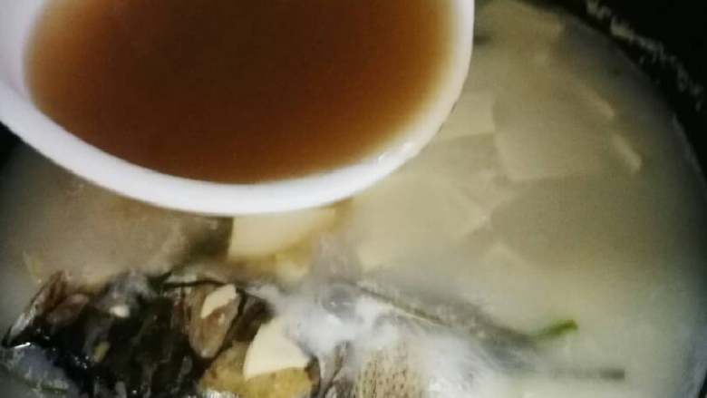 糟泥鱼头豆腐汤,过滤后的糟泥水加入到炖着的鱼头汤里。加入盐调味,再继续炖会儿。