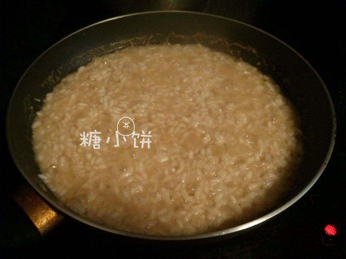 西式苹果炖饭,大火烧开后转中火炖煮,水分几乎收干的时候米粒也熟透了,等待炖饭的空暇时间可以把苹果去皮,切成1cm见方的丁备用