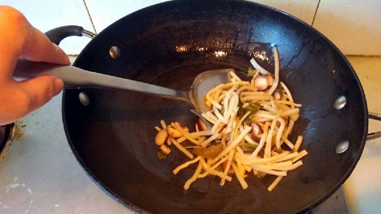 酸辣汤,锅里放油适量,油八成热下笋丝、香菇和酸菜叶翻炒。