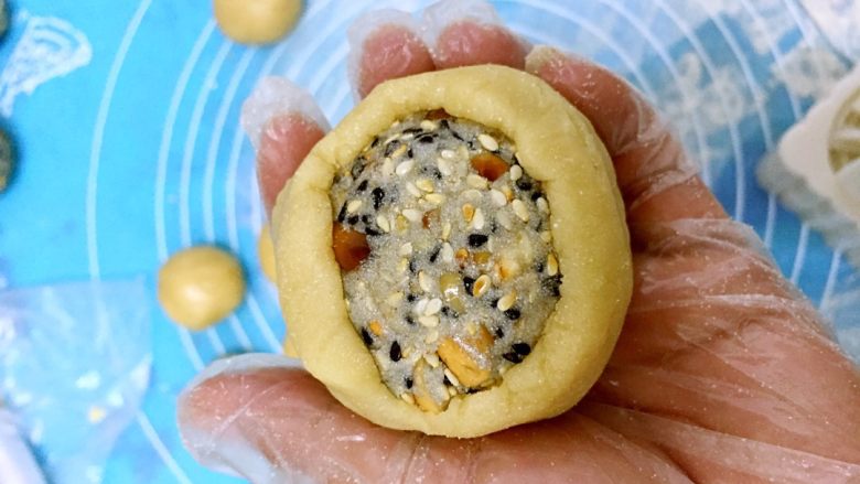 五仁低糖月饼➕#中秋食饼记#,放入五仁馅料,用手慢慢往上推,皮将陷完全包裹。