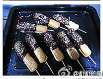 巧克力棒棒蛋糕,把蛋糕沾上巧克力,撒上糖珠冷却。