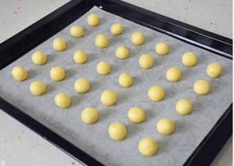 萌媚酥香的玛格丽特饼干,再把小面球整齐的摆放到烤盘中，每个都要留出足够的间距。