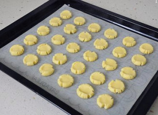 萌媚酥香的玛格丽特饼干,用拇指轻轻按压小面球，至其成饼状，边缘有开裂即可，也别按压的太薄，要稍有厚度才好。