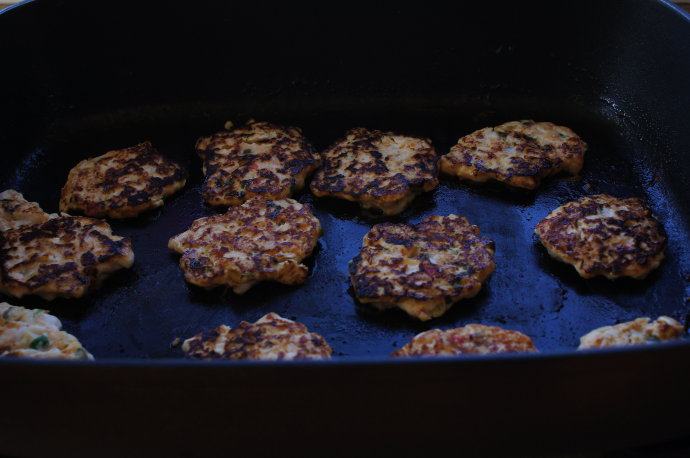 泰式鸡肉饼,平底锅热油,偶用oil spray,油喷得很均匀。锅热后,用汤勺勺一勺鸡肉混合物放入平底锅,稍摊平,每面煎3分钟左右直到鸡肉全熟。