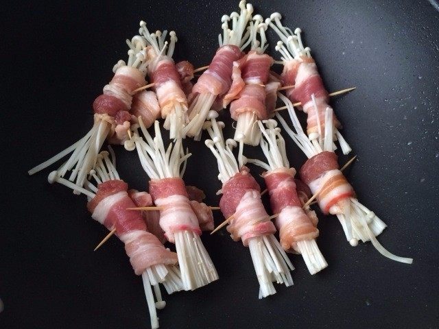 五花肉金针菇卷,预热电烤炉5分钟,刷上一层油,把五花肉卷放进烤炉慢慢煎烤