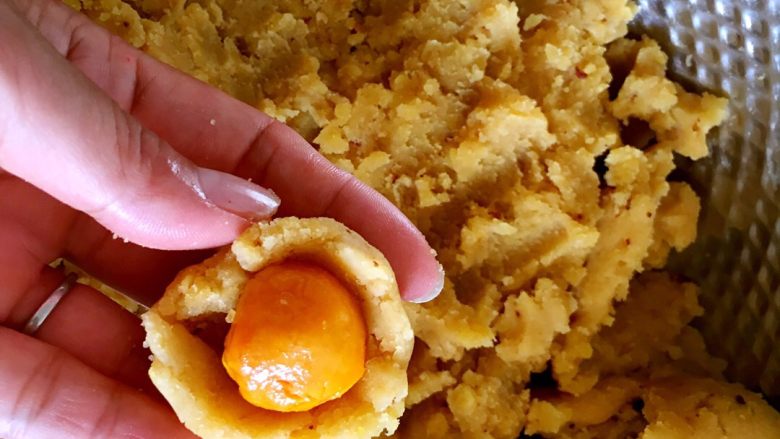 广式绿豆沙蛋黄月饼+#中秋食饼记#,把绿豆糕捏成碗状,包入蛋黄。
