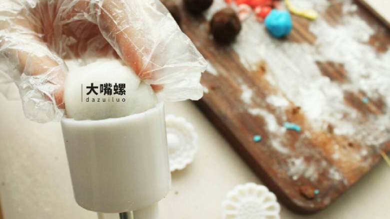 Q萌红糖冰皮月,包好后的冰皮红豆沙裹一层熟糕粉,放入模具中压紧实,顺着模具压就完成了
