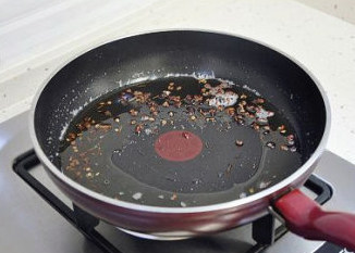 朋友圈火卖的麻辣牛肉 ,锅中加入花生油,再放入麻椒用最小火慢慢炒至能闻到麻椒的香味,然后将麻椒捞出。