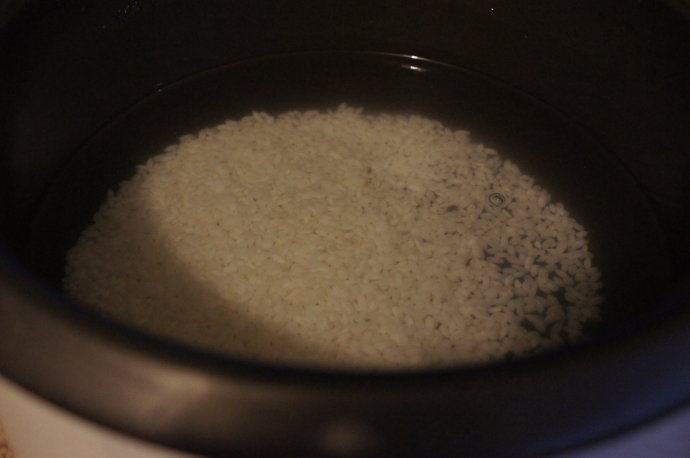 电饭锅芥菜肉粥,珍珠米用水浸泡一个晚上。第二天淘洗好米,放入电饭锅,加入足量的水。盖上锅盖,插电源,按煮饭或者煲粥功能键。