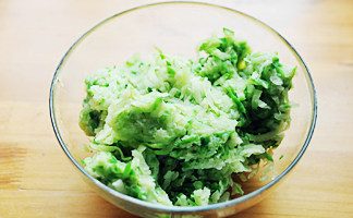 美食源于民间【炸萝卜丸子】,擦好的萝卜丝放入沸水中煮开，捞出过凉后，控掉水分并用双手用力挤压萝卜丝，挤出多余水分；