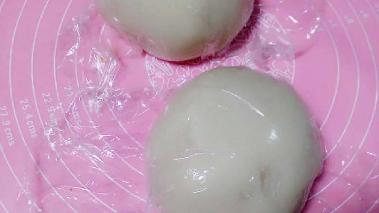 冰皮月饼#中秋食饼记#,稍微凉一下,感觉手可操作的温度取出及时揉匀,揉好的面团均分两份,包保鲜膜室温晾凉即可,这就是做好的冰皮
