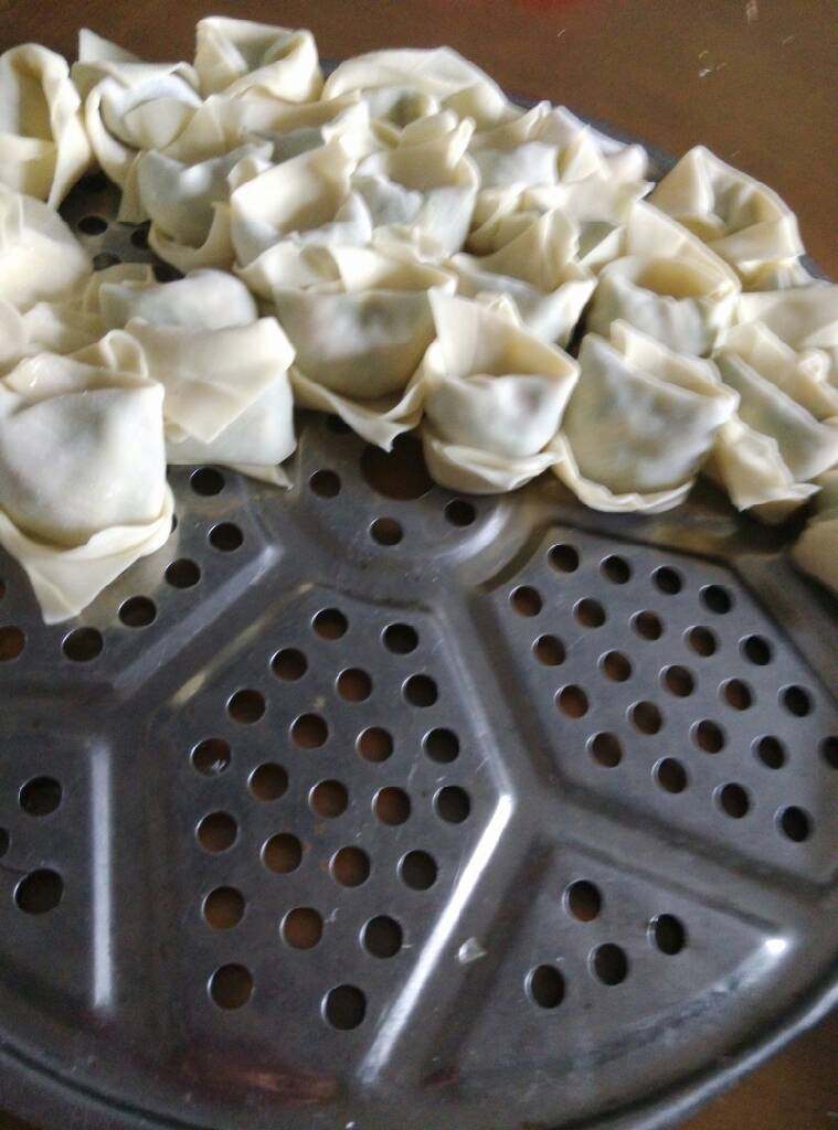云吞,取一片面皮包入拌入葱花的肉末,包好,反过来放。(因为云吞皮薄,这样放不容易穿孔)