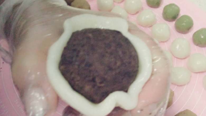 冰皮月饼#中秋食饼记#,用手把冰皮捏成四周薄中间略厚的圆片,取馅料放进冰皮中包好捏紧