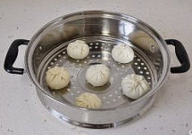 【鲜肉大包】,包好的包子放入底部刷油的蒸屉中,包子间要留有间隙,然后再室温醒发15分钟。