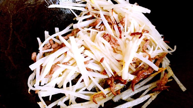 虾米萝卜丝炒豆渣,下萝卜丝翻炒片刻,炝料酒,加适量盐调味后炒匀。
