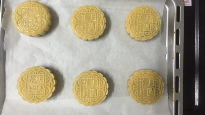 莲蓉蛋黄月饼(Moon Cake)#中秋食饼记#,然后用虎口把莲蓉馅和鸭蛋黄封口，搓成圆形，用月饼模具压出花型出来。然后给月饼上面喷点水，防止月饼开裂。