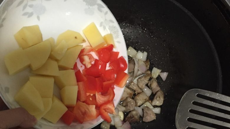好好ci牌 咖喱土豆排骨焖饭,将洋葱炒香,依次放入红椒、土豆。