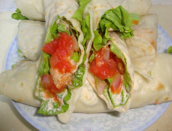 热力四射:墨西哥鸡肉卷,放上<a style='color:red;display:inline-block;' href='/shicai/ 121'>生菜</a>叶、码上鸡柳,在两端分别放上调好的番茄酱和沙拉酱,卷起来