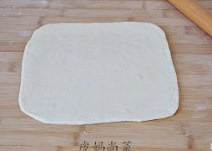 海鲜披萨 ,将面团分成两个相同的剂子,取其中一个,擀成方形薄片状。