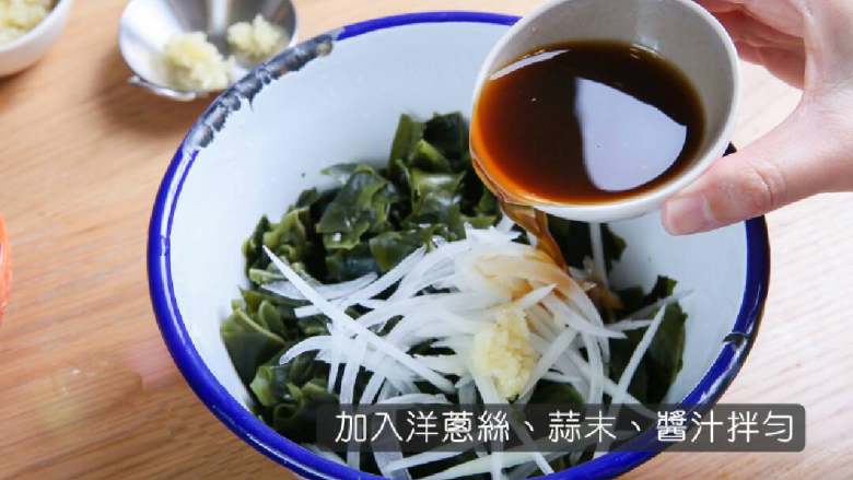 凉拌海带芽 ,拿一个大碗,放入海带芽、洋葱、蒜末,淋上酱汁搅拌均匀试试看味道,如果海带芽太多,酱汁不够就按照比例再多加一点酱汁
