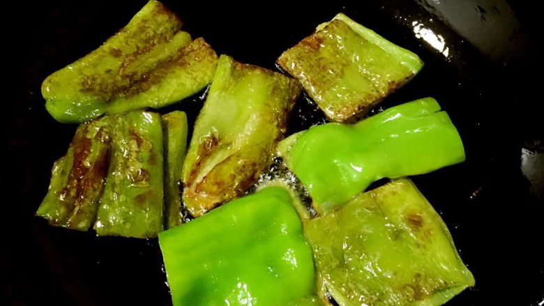 虎皮尖椒,中火热锅下入尖椒,先煎一面,再煎另外一面。掌握不好的就反复多煎几遍