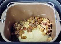 【酒香核桃面包】,揉至面团能拉出薄膜，放入核桃仁，以及泡软的葡萄干，要沥干酒液后加入。再揉面5分钟。