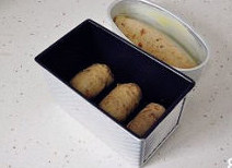 【酒香核桃面包】,将面卷按照模具的宽度大小整好后放入模具中，让面包坯做二次发酵。