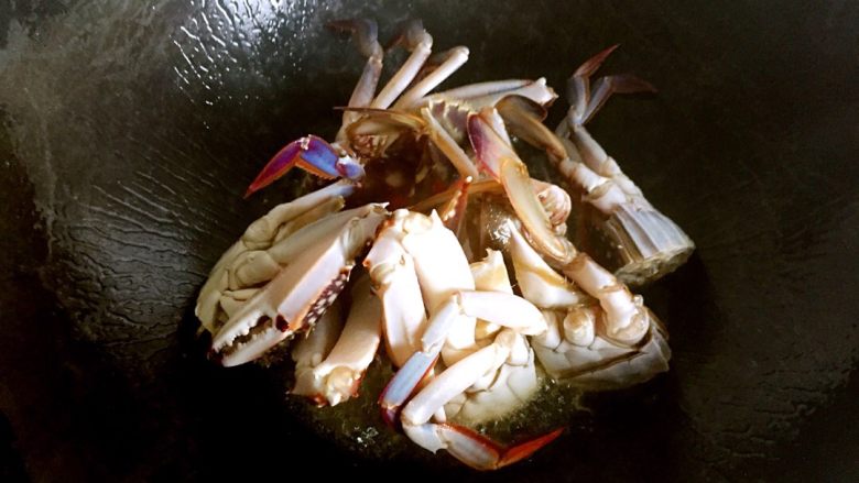 梭子蟹炒年糕,锅烧热,放油(比平时炒菜多一点),油七分热,将螃蟹的切面放油锅中烧炸,定型。