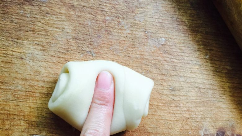 蛋黄莲蓉月饼,取一个松弛好的面卷,食指按压中间