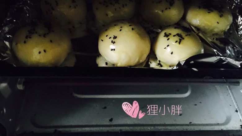 蛋黄莲蓉月饼,表面刷蛋液,撒黑芝麻,烤箱170度预热,上下火30分钟,中间可以再刷一次蛋液,表皮颜色更漂亮,各家烤箱略有差异,可以根据实际情况延长或者缩短