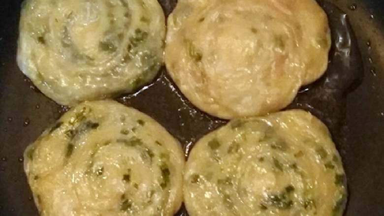 葱油饼,不粘锅倒入适量的油,加入葱油饼用中小火慢慢煎至两面金黄色即可。