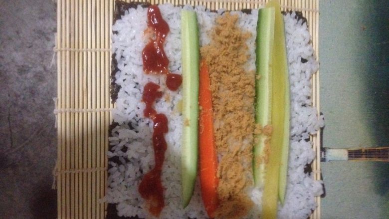 肉松寿司,将帘子平铺,拿一张海苔放在帘子上,放米饭、调味萝卜、胡萝卜、黄瓜、<a style='color:red;display:inline-block;' href='/shicai/ 432'>肉松</a>!根据自己的口味放入酱(番茄酱、沙拉酱、鱼子酱……)