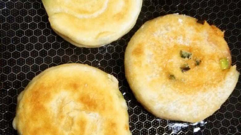 改良版葱油饼,锅烧热，加点油再下面饼，煎一会以摇锅的方式能把面饼摇松动了就翻一面再煎，当然你也可以用铲子，煎到两面金黄就可以了