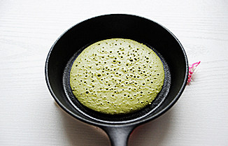 蜂蜜抹茶铜锣烧,不沾平底锅抹少许油,烧热后舀入一勺面糊,小火慢烙,待边缘凝固用竹签能轻易挑起且表面有很多气孔时,翻面烙另一面至上色后取出;