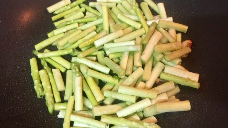 黑椒白芦笋炒牛柳,倒入白芦笋,翻炒30秒,加少许盐拌匀