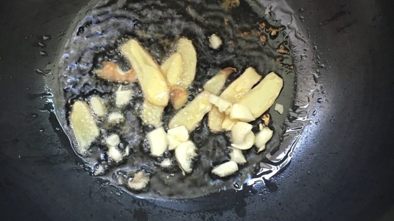 #红烧栗子鸡#,锅中倒入少许油,加热,放姜片蒜瓣爆香。